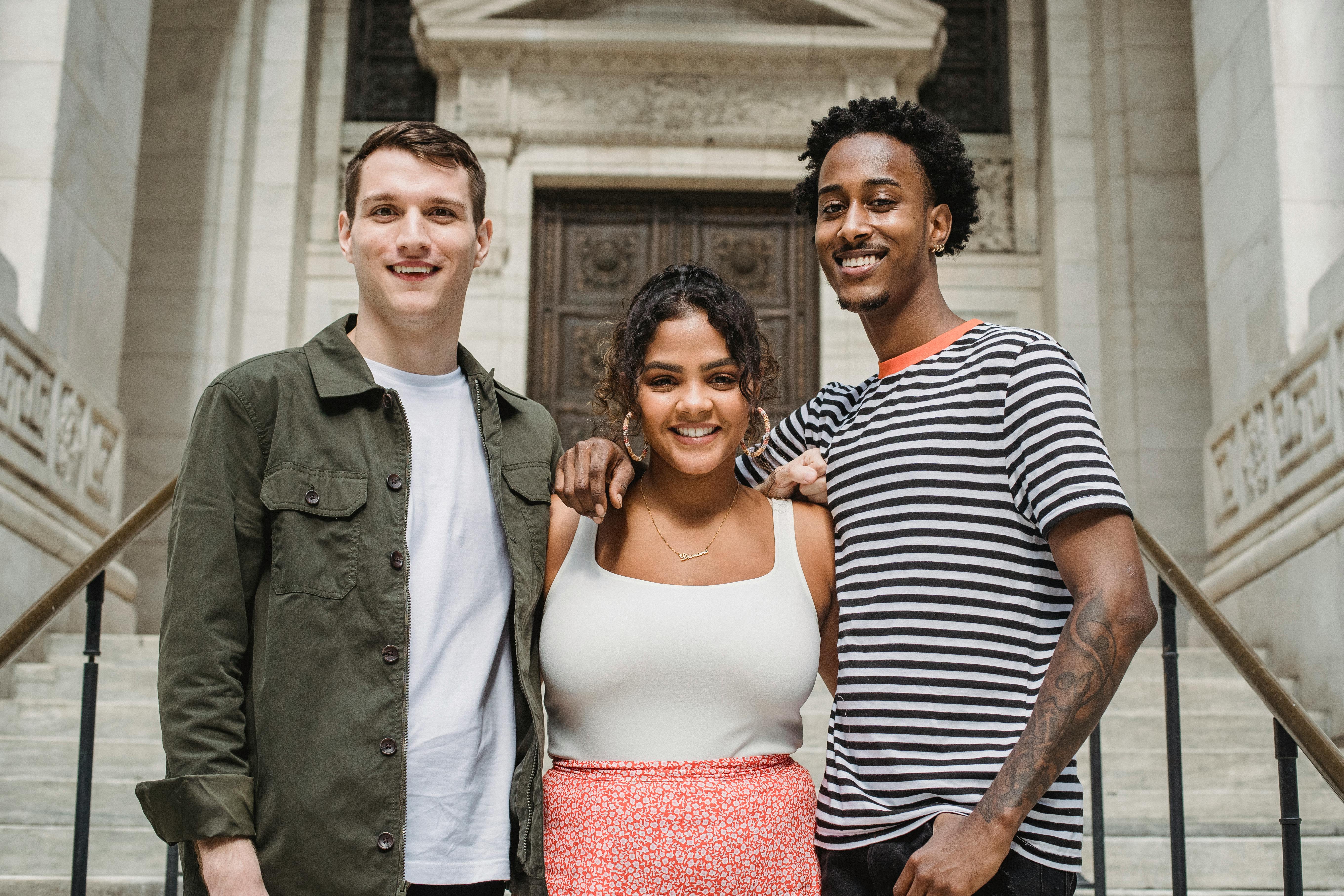 Three diverse young adults smiling together